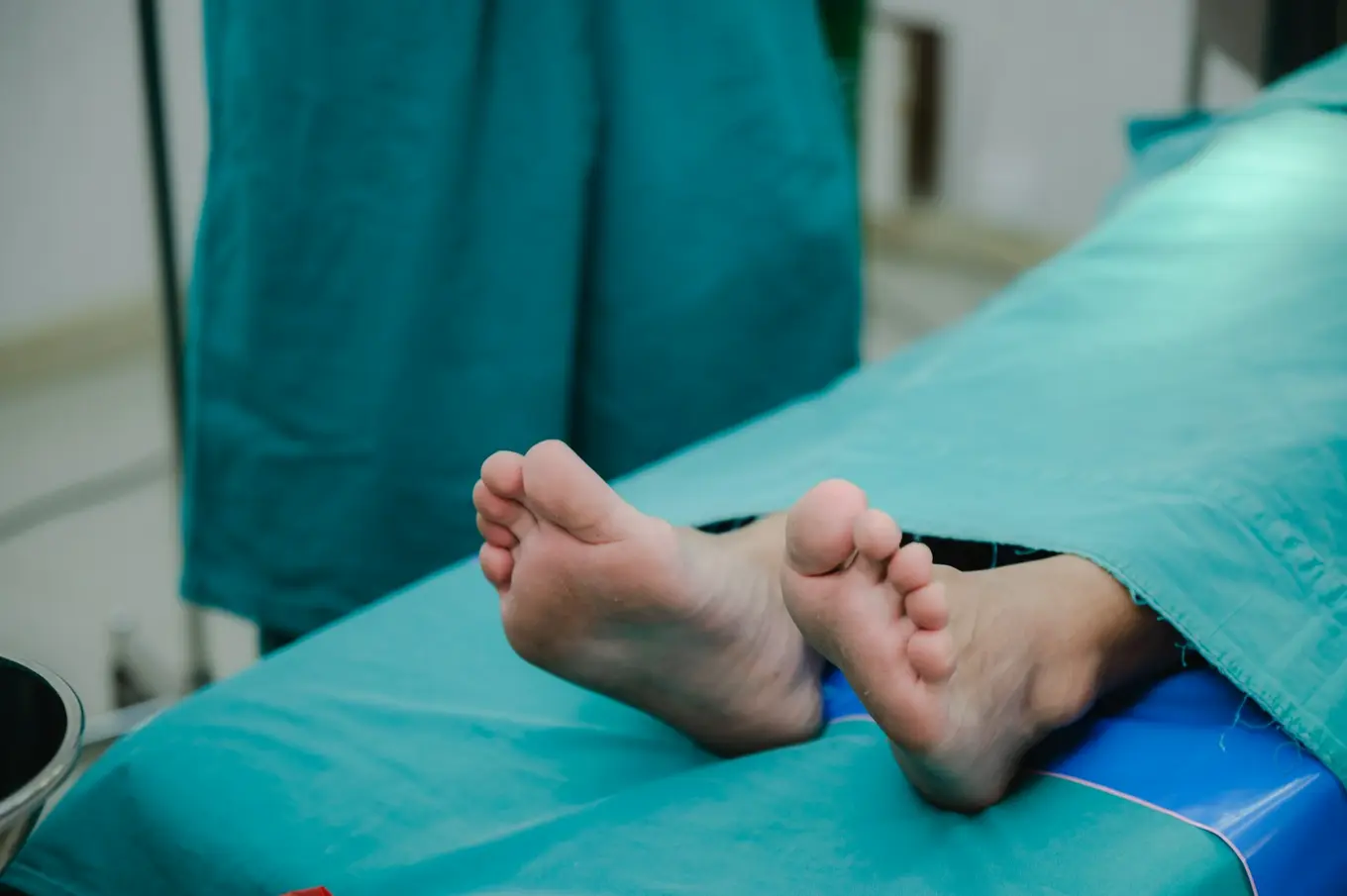 stopy pacjenta na szpitalnym łóżku